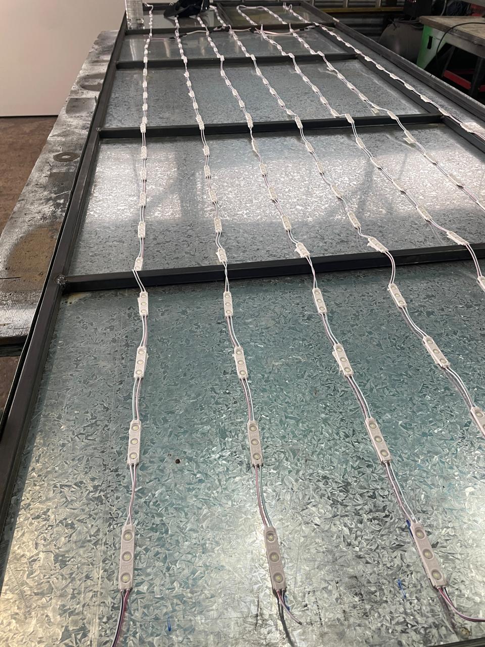 Matriz de módulos LED instalados y cableados sobre chapa galvanizada en taller