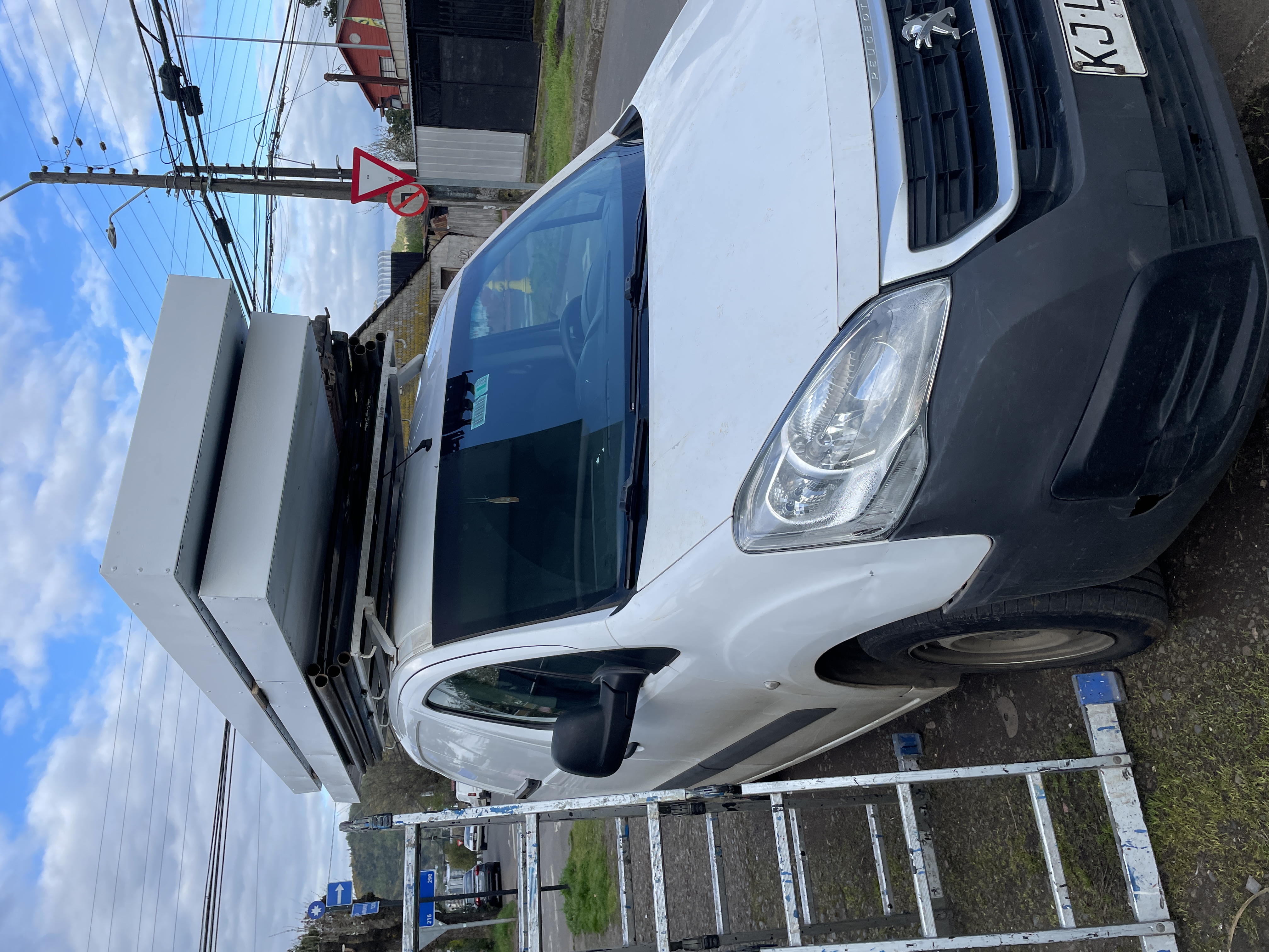 Camioneta de instalación de Multicarteles con estructuras y escaleras listas para terreno