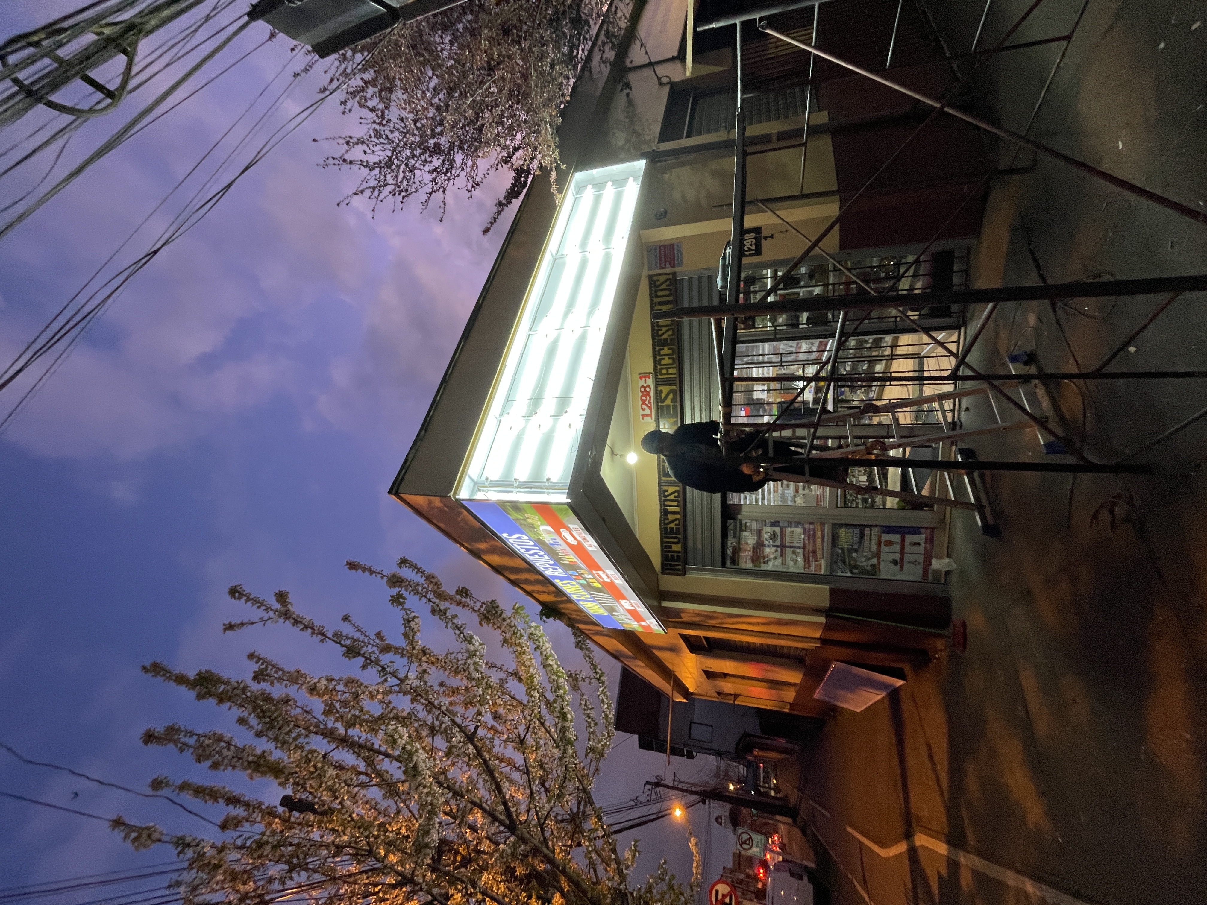 Marquesina y caja de luz para tienda de repuestos automotrices al atardecer